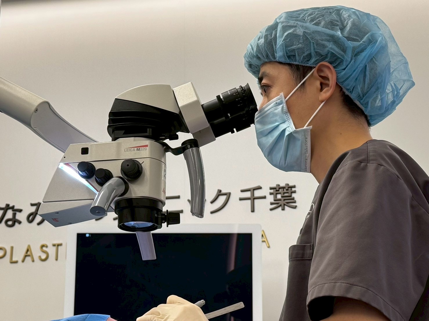 顕微鏡下で手術を行う石田院長